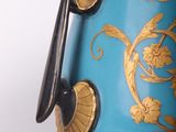 a blue vase with gold decoration on it on a stand