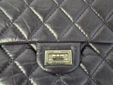 an image of a black quilted purse on a table
