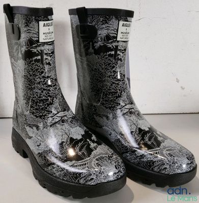 une paire de bottes de pluie noires et blanches posées sur une table