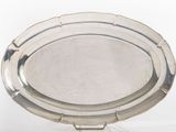 a silver plate on a stand on a white surface