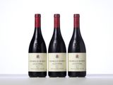 three bottles of red wine are lined up on a table