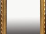 a gold framed mirror sitting on top of a wooden table