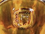 a close up of a brown bowl with a brown design on it