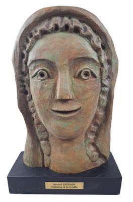 sculpture of a woman ' s head with a smile on a wooden base