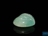 a close up of a green jade heart shaped object on a black surface
