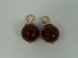 a pair of red glass beads with gold bails