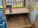 a cage with a shelf in the middle of a room