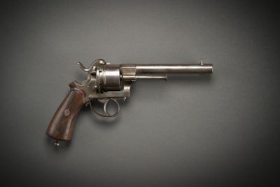 a close up of a revolver on a table with a black background