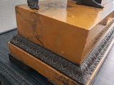 a statue of a man holding a box on a table