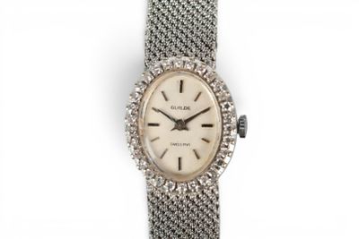 a close up of a watch on a white surface with a white background