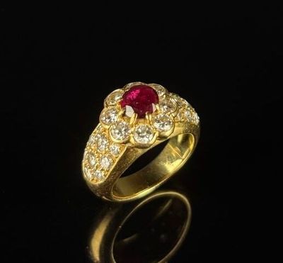 a close up of a gold ring with a ruby stone