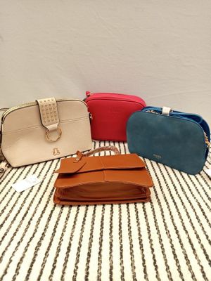 four purses are lined up on a striped table cloth