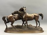 sculpture en bronze représentant deux chevaux se battant l'un contre l'autre, posée sur un socle
