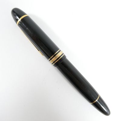 une image représentant un stylo noir orné de finitions dorées, posé sur une surface blanche