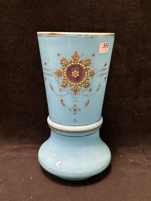 un vase bleu orné d'une décoration dorée