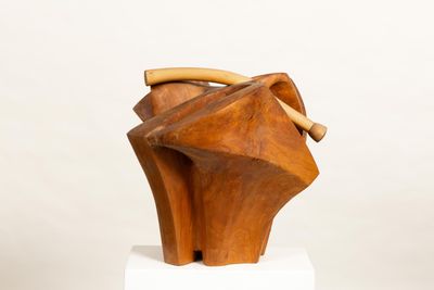 wooden sculpture of a woman ' s head with a wooden handle on a pedestal