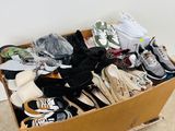 a cardboard box full of shoes on the floor