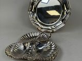 an antique silver plate with a mirror on top of it