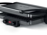 a close up of an electric grill on a white surface