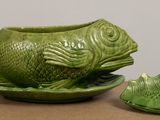 a green bowl with a fish on it next to a green bowl with a fish on it