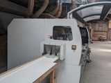 a machine that is cutting a piece of wood in a factory