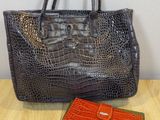 an orange and black purse sitting on top of a wooden table
