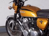a yellow motorcycle parked in a garage next to a white wall