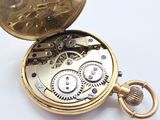 a close up of a pocket watch on a white surface