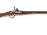 un vieux fusil avec un canon en bois et des garnitures en laiton