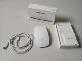 a white apple mouse next to a white box on a table