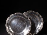 a pair of silver plates on a black background