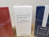 three boxes of perfume sitting on top of a table next to each other