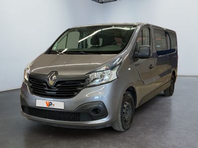 La camionnette argentée est garée dans une grande pièce équipée d'un ventilateur de plafond.