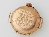 a gold pocket watch on a white surface