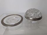 a glass box with a silver lid and a plate on it