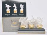 trois flacons de parfum posés sur une table à côté d'une boîte de parfums