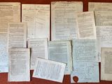 Plusieurs vieux papiers sont empilés sur une table, à côté d'une feuille de papier