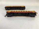 two model trains sitting on top of each other on a white surface