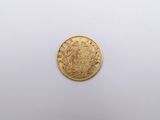 a close up of a gold coin on a white surface