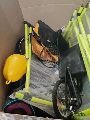a cardboard box filled with various items including a stroller and a bicycle