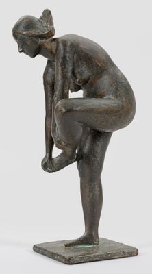 statue en bronze représentant une femme penchée en avant, posée sur un socle carré