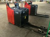 two forklifts that are sitting in the middle of a warehouse