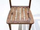 a wooden chair that is sitting on a white surface