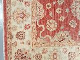 a red and beige rug with a floral design on it