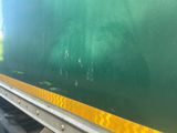 a green train car with a yellow stripe on the side of it