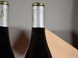 two bottles of wine sitting next to each other on a table