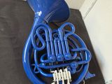 a close up of a blue french horn on a table