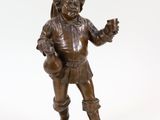 figurine en bronze représentant un homme tenant un sac et montrant quelque chose du doigt