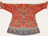 an old red and blue chinese dress with a dragon on it