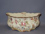 a white bowl with flowers on it on a table